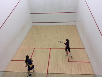 University of Lincoln's women's team cmpetitor againt one of the members of the Anglia Ruskin Squash team